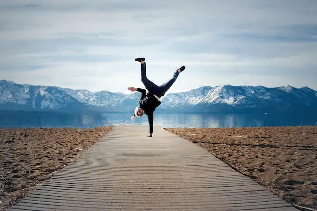 man doing hand stand on the beach