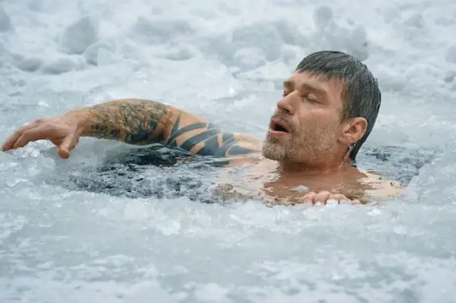 man swimming in frozen water
