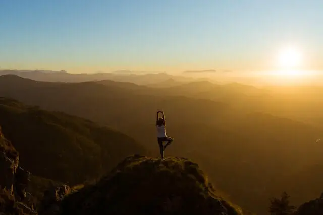 woman stretching on mountain