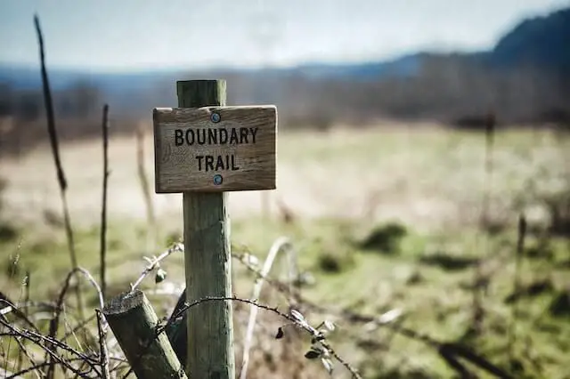 boundary trail wood sign in a field