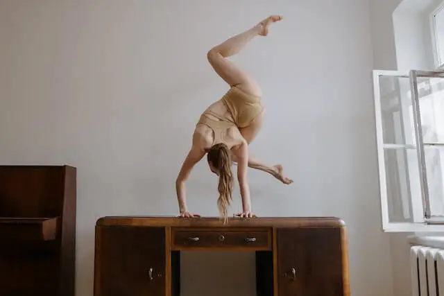 woman doing hand stand on the table