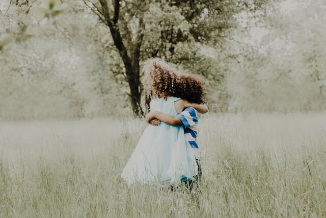 boy and girl hugging in a field