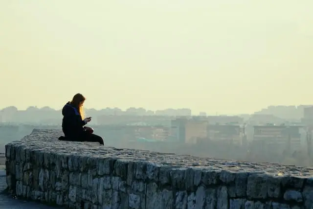 woman sitting on a gray concrete